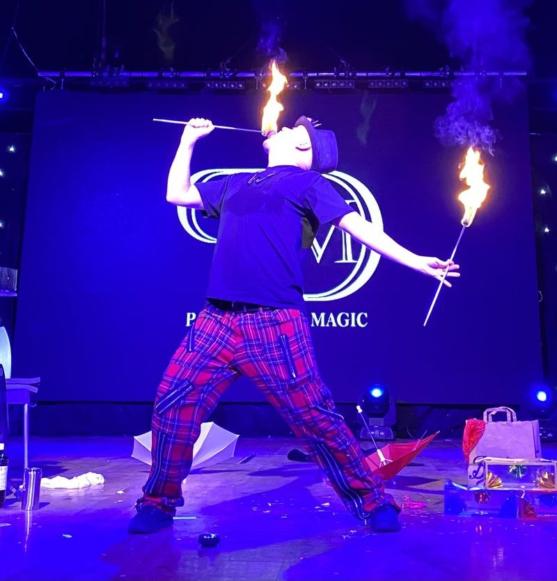 Paul the Magician performing a fire stunt during his live stage show