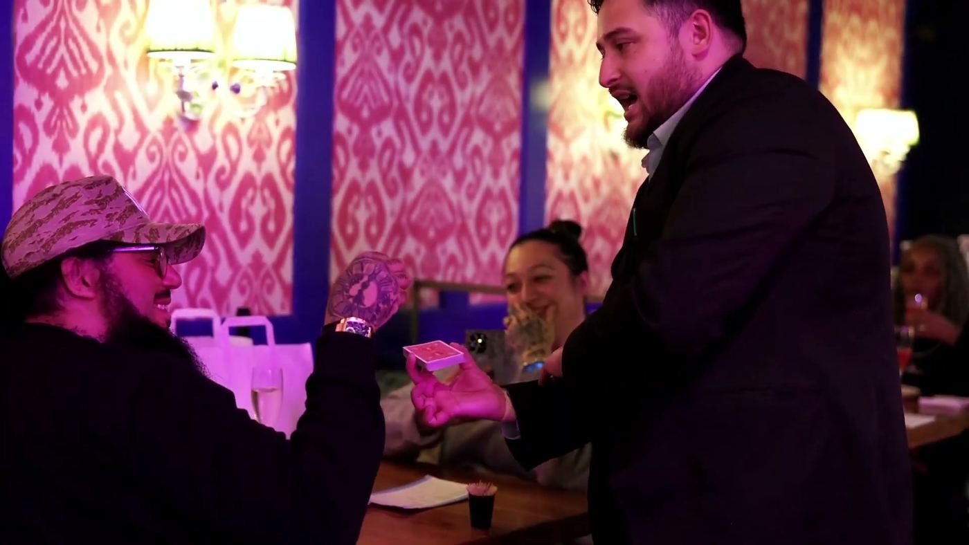 A guest reacting as a playing card is handed to her