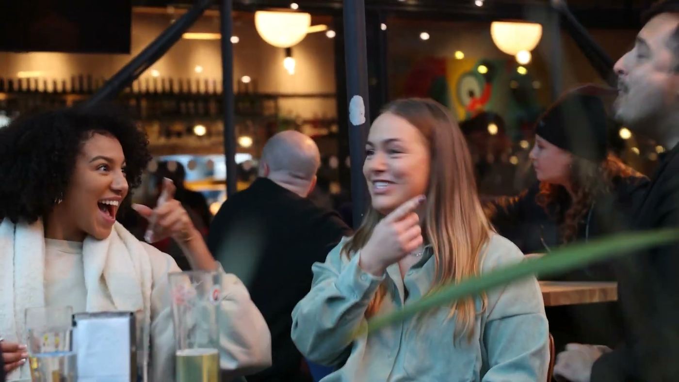Two guests laughing during a drinks reception performance