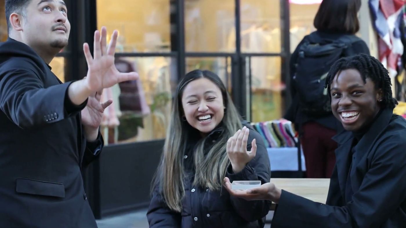 A couple laughing as a trick is performed for them