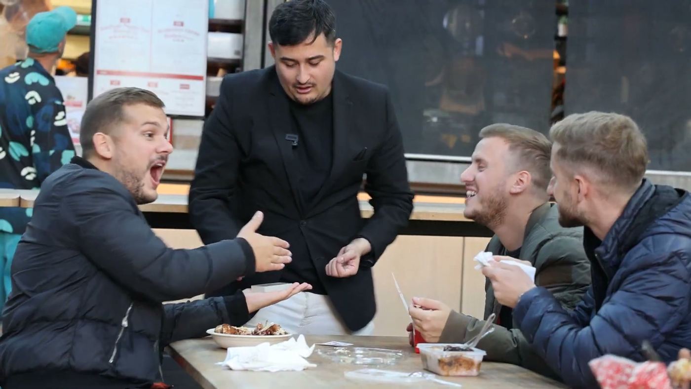 A guest gasping at a close-up trick at a street-food table