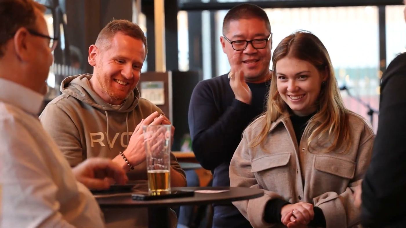 A table of guests laughing at a close-up magic routine