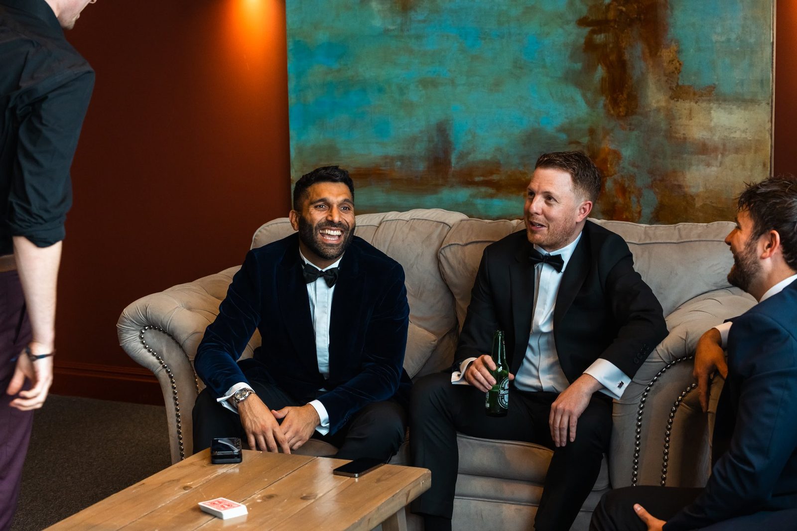 Black-tie guests smiling as a card trick unfolds at a corporate evening