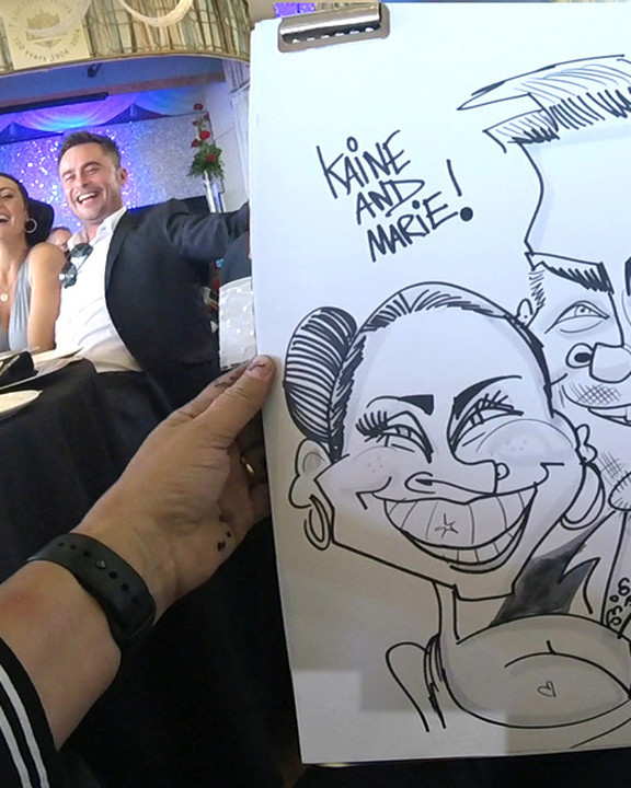 Wedding guests with their couple caricature at the reception