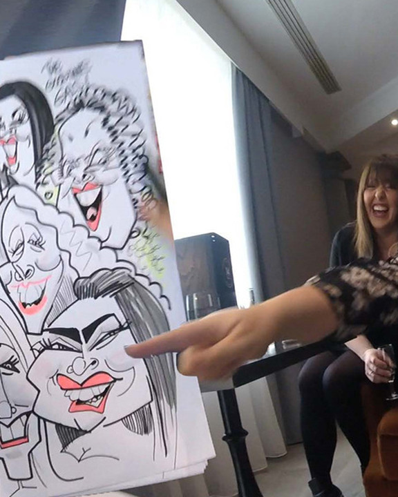 Group of friends pointing at their group caricature