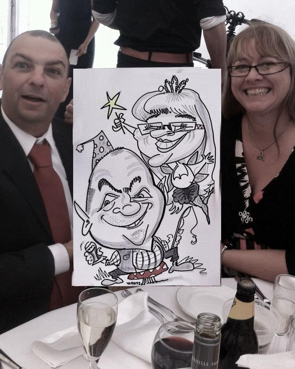 Couple at a wedding breakfast table with their caricature
