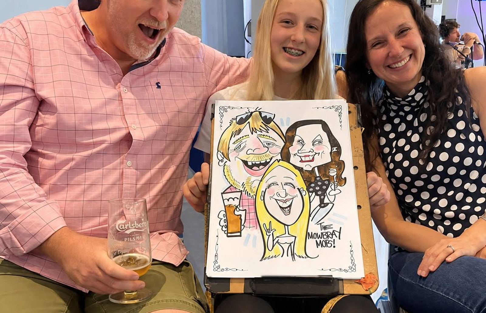 Family holding their live colour caricature by Cheeky Caricatures