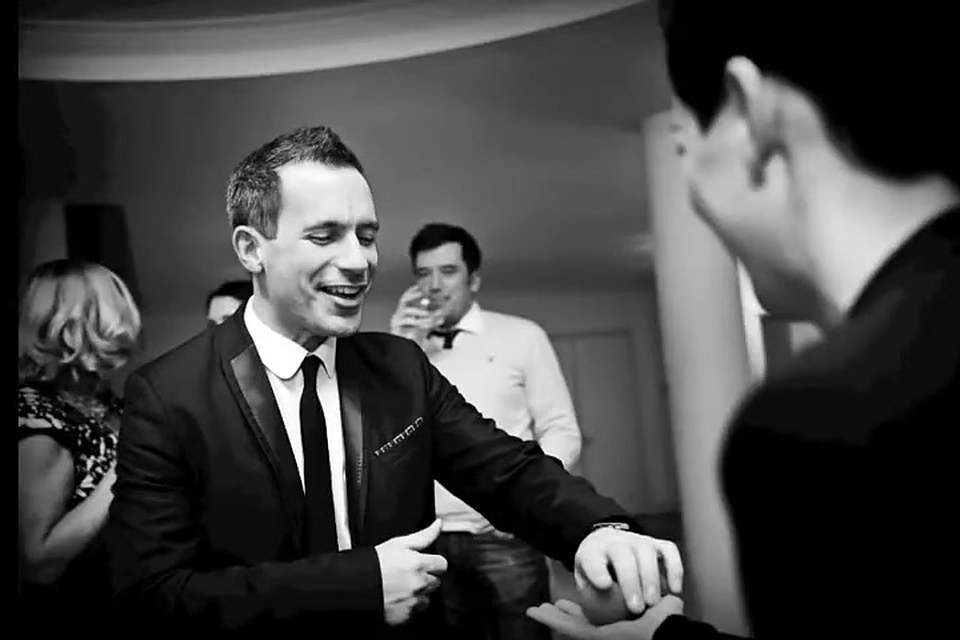The magician performing walkaround magic for guests at a party