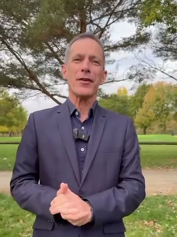 David, a London magician, in a suit outdoors in autumn