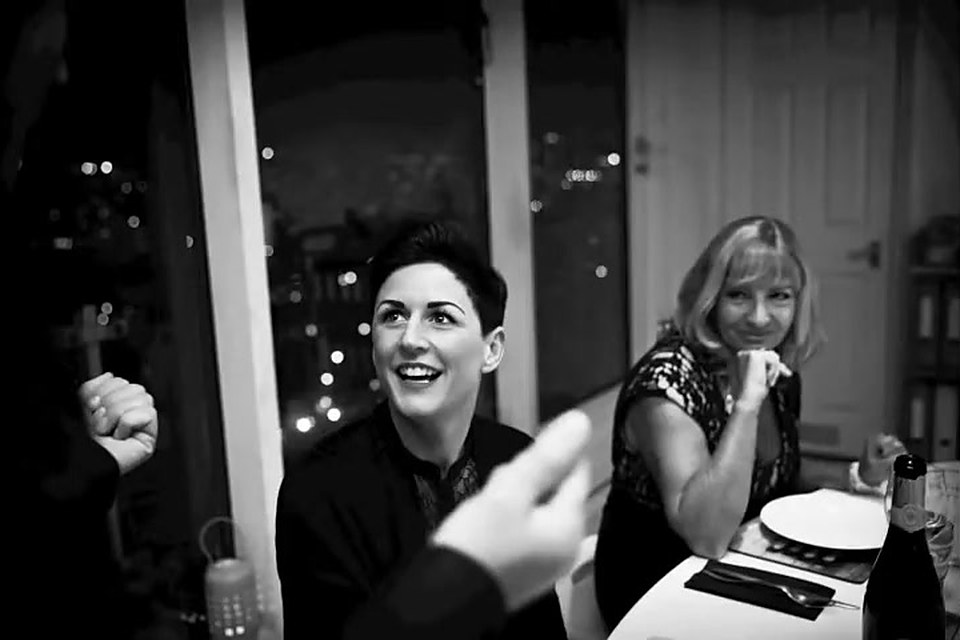 Two guests laughing at a dinner table as the magician performs close-up magic