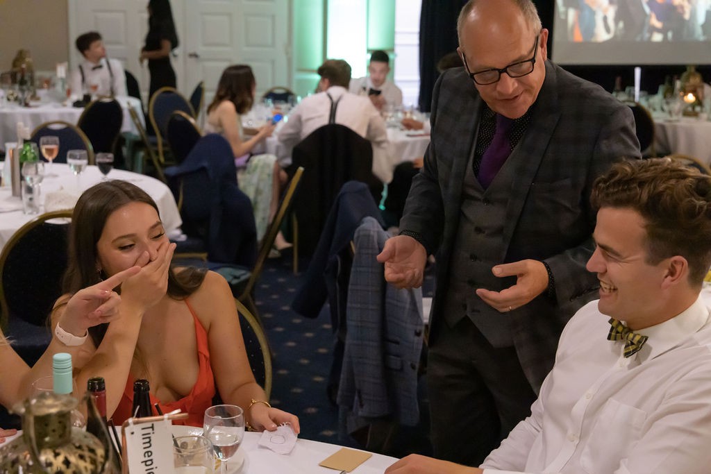 A guest with her hand over her mouth after a trick at a wedding reception