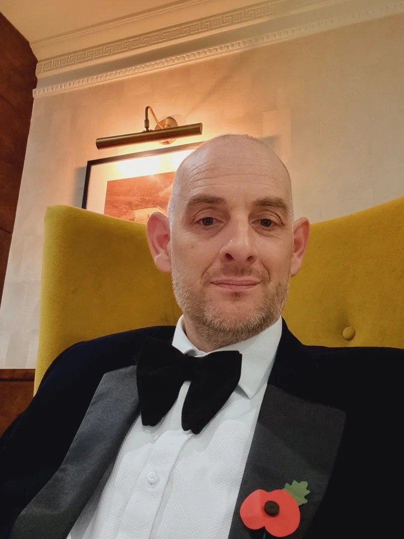 Richard, magician and event host, in a black tie dinner suit at an evening event