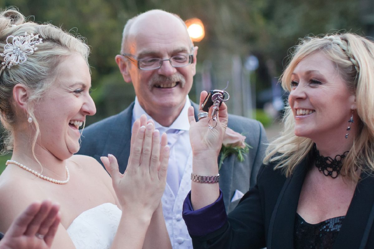 A bride and wedding guest reacting with delight to a magic trick