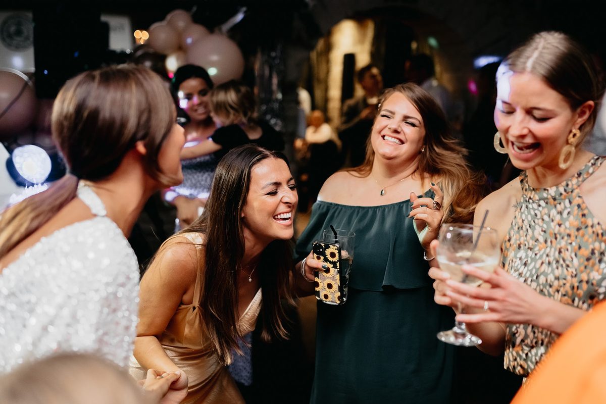 Party guests laughing in amazement around the magician