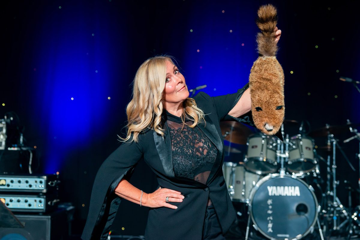 Aurora Myst on stage during a corporate show with a volunteer prop