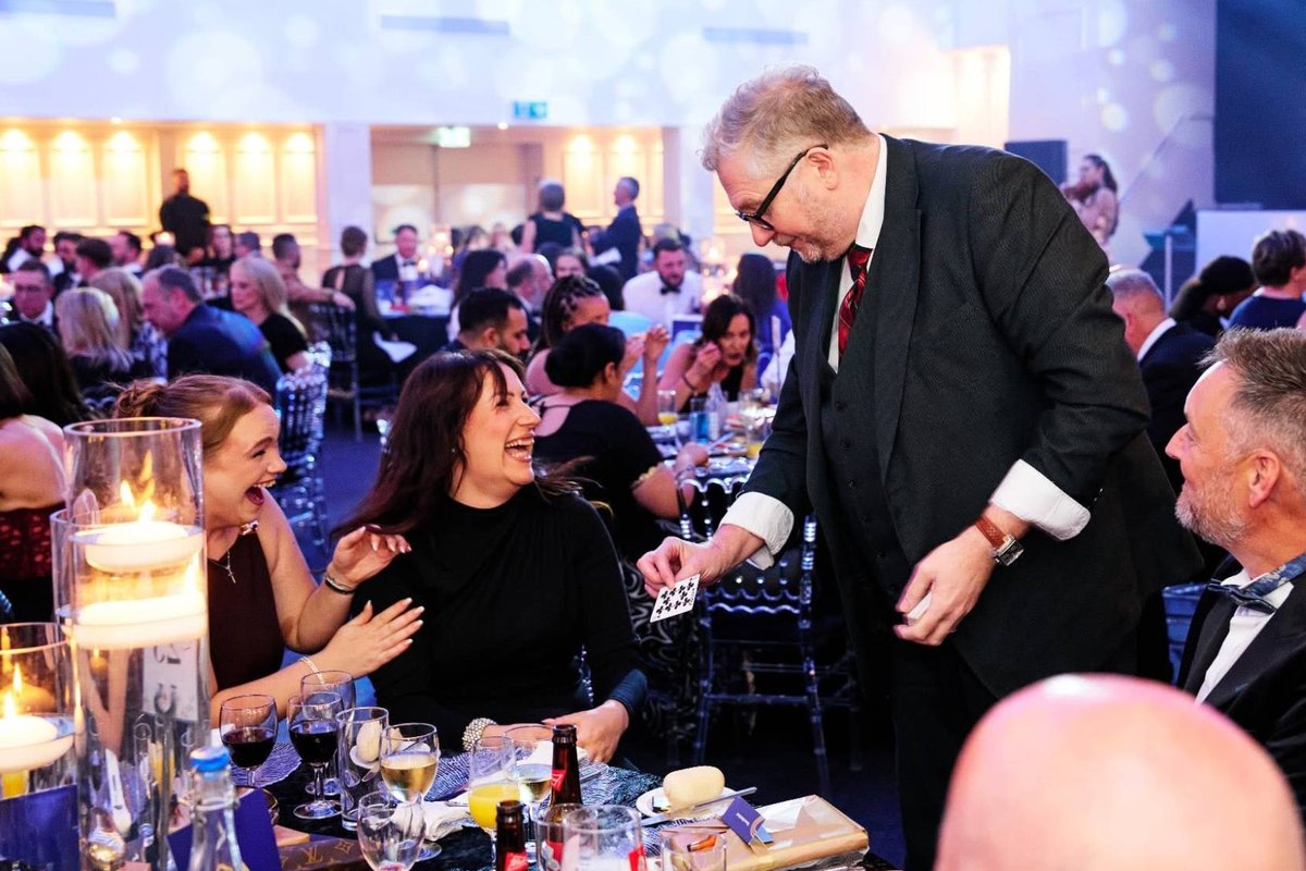Banter Magic revealing a playing card to delighted guests at a corporate awards dinner