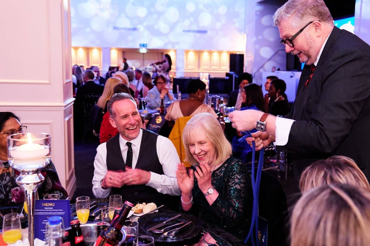 Guests clapping and laughing as Banter Magic performs a rope trick at their table