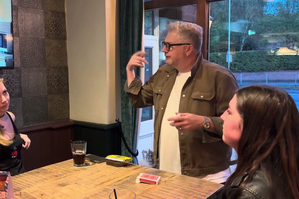 Banter Magic chatting and joking with two guests at a table before a card trick