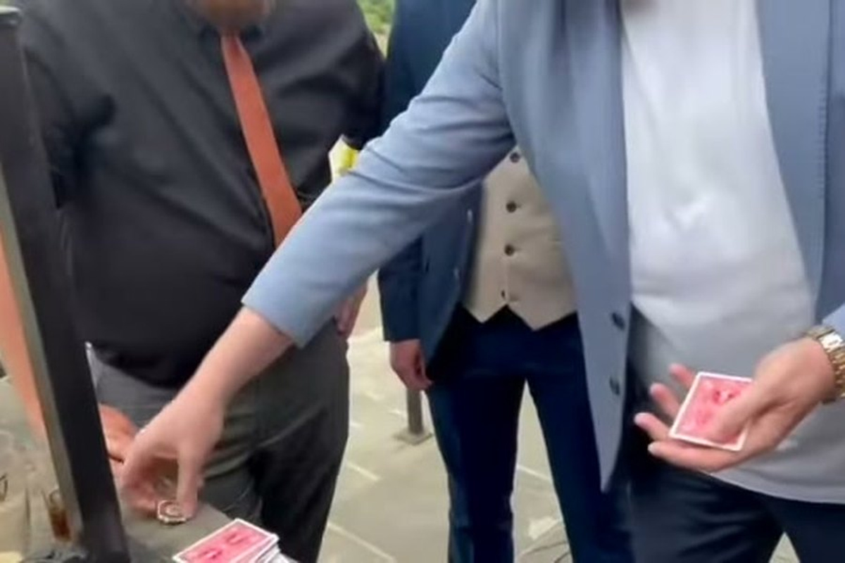 Banter Magic performing a card trick for wedding guests on a terrace