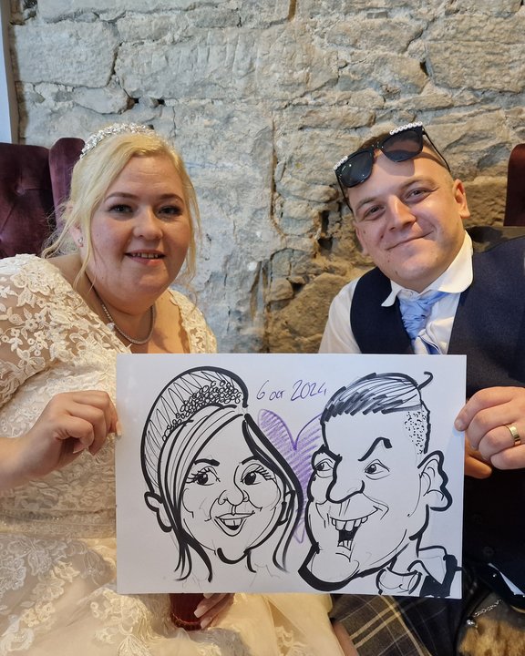 Bride and groom holding their live wedding caricature