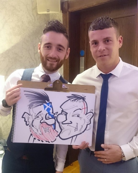 Two wedding guests holding their double caricature