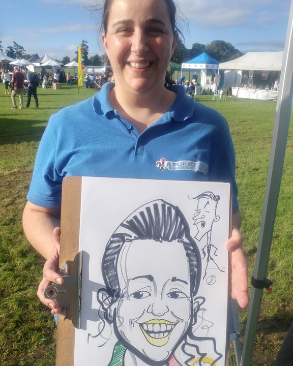 Festival staff member holding her colour caricature
