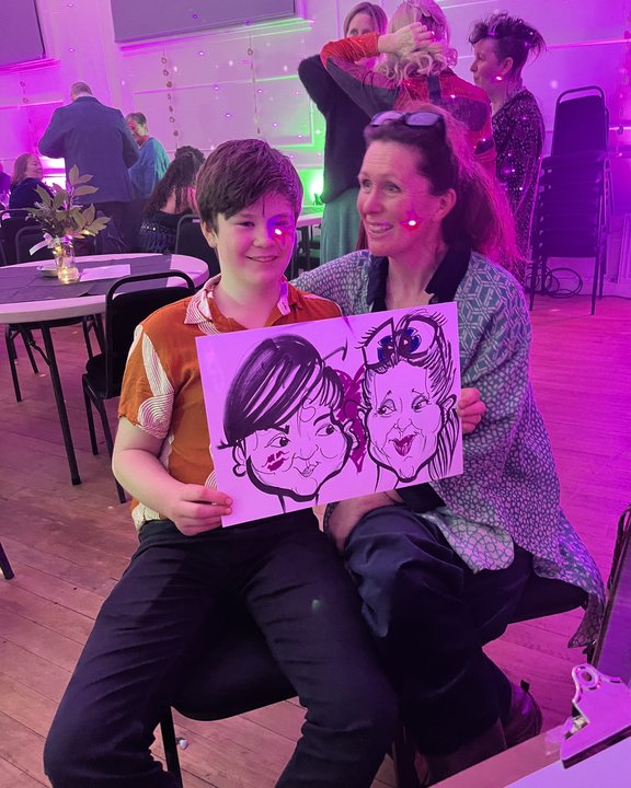 Two guests with their colour caricature at a party