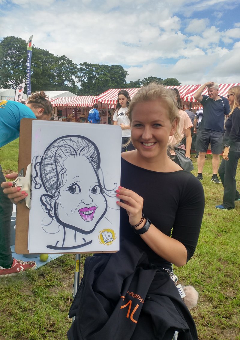 Festival visitor holding her live caricature