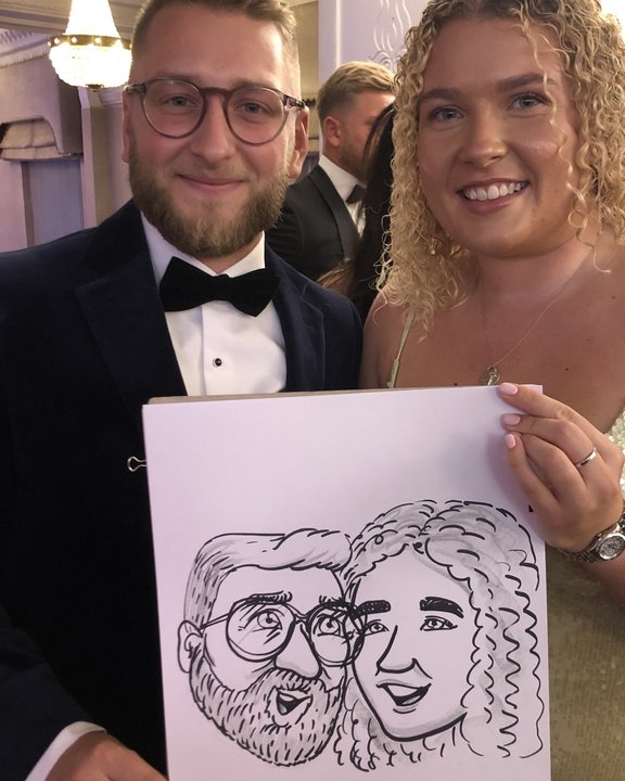 Couple in black tie with their live caricature at a gala