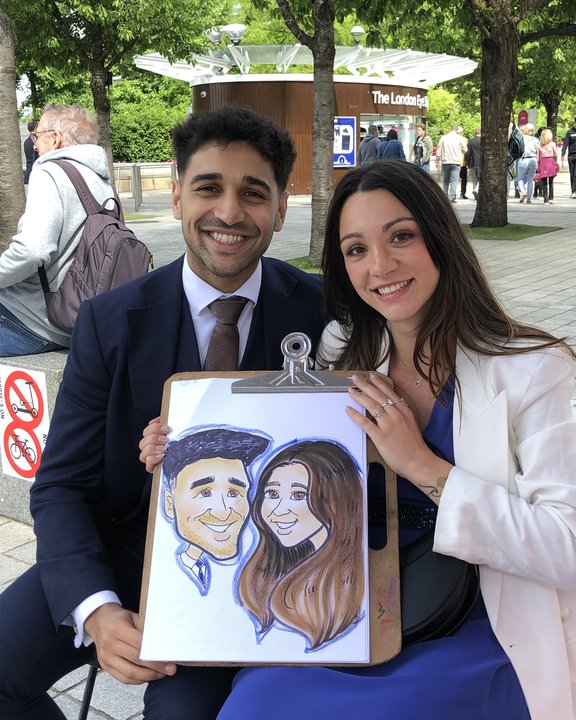 Couple with their colour caricature by the London Eye