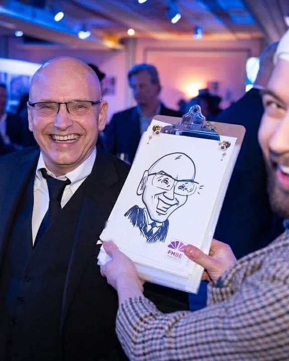 Guest holding his caricature at a Christmas party