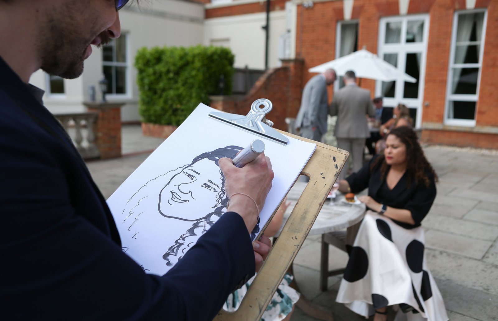 Capital Caricatures drawing a guest live at an outdoor garden event