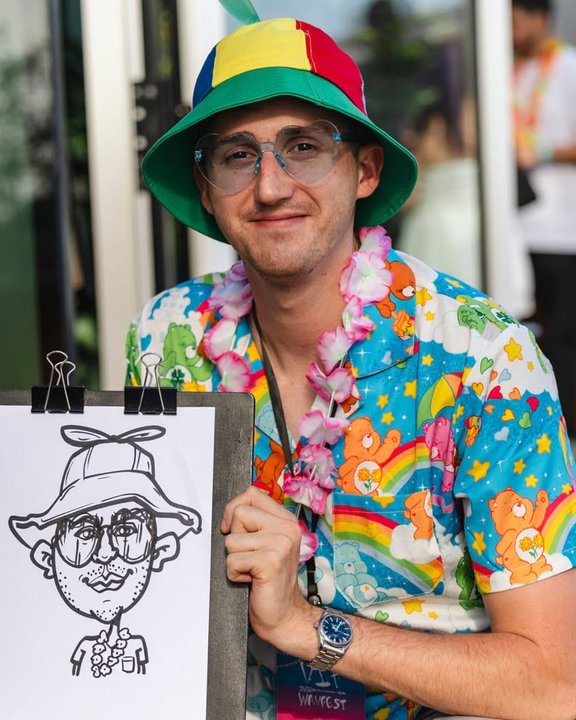 Guest in a bucket hat and Hawaiian shirt with his caricature at a summer party