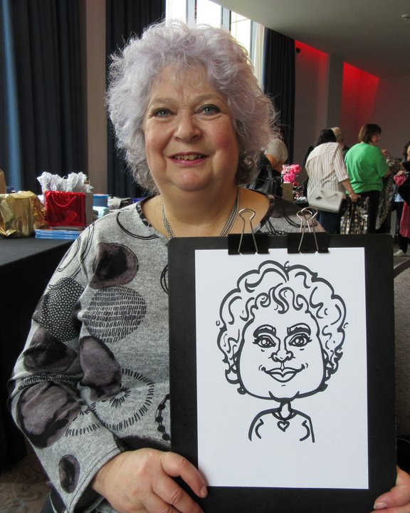 Smiling guest holding her live caricature at a party