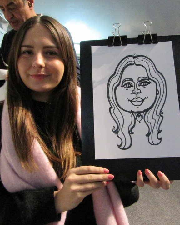 Guest holding up her live caricature at an event