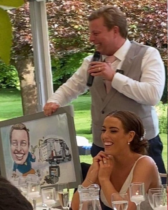Best man revealing a framed colour caricature during the wedding speeches