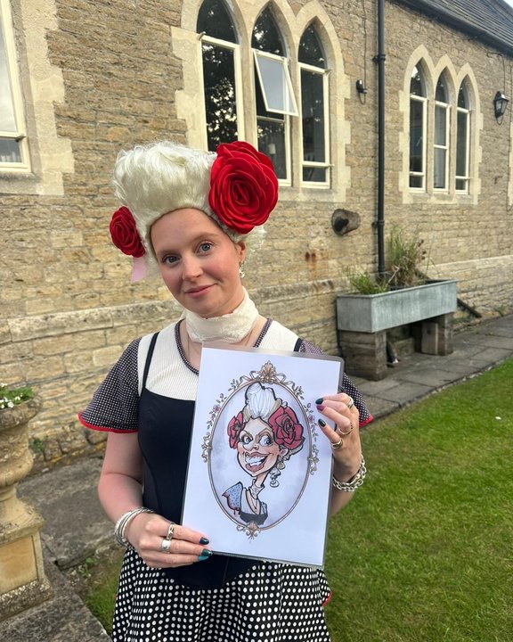 Guest in a white period wig with red roses holding her colour caricature at an outdoor party