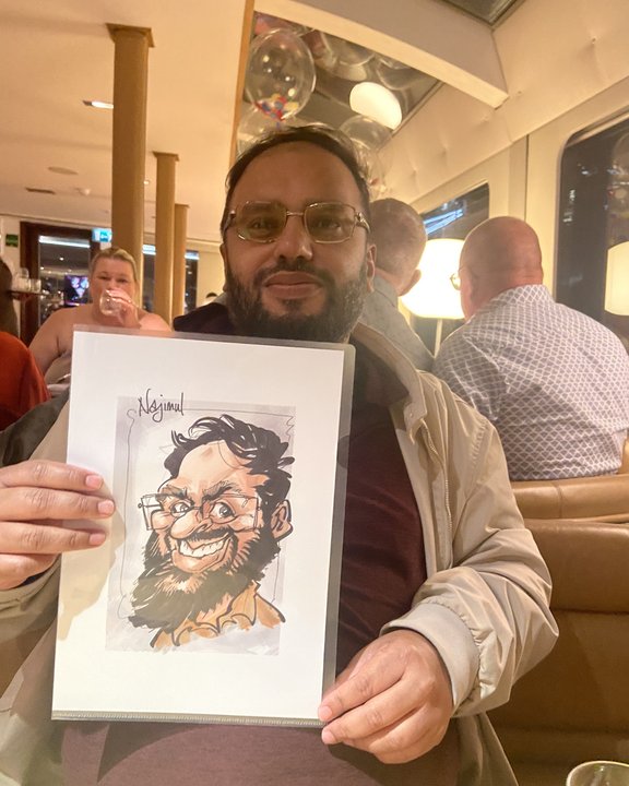 Smiling guest holding his colour caricature at a restaurant party