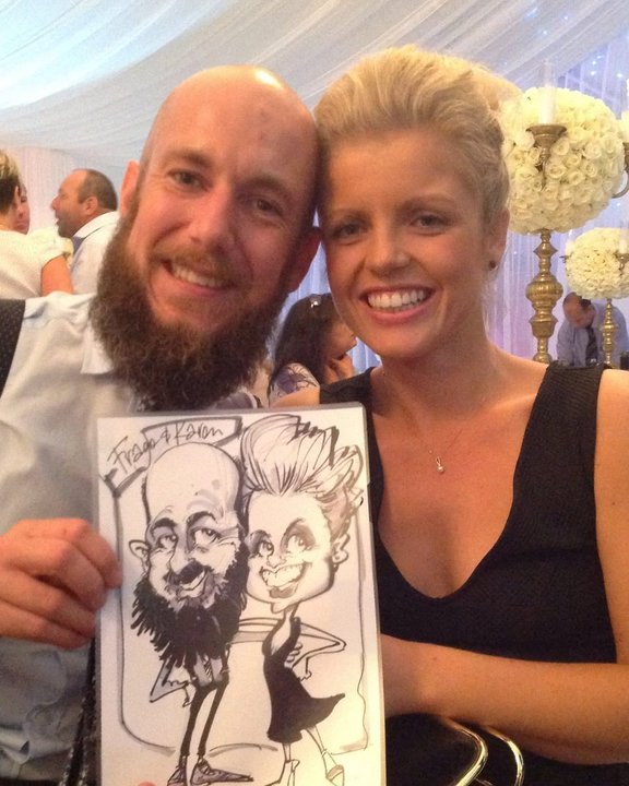 Couple holding their black and white caricature in a wedding marquee