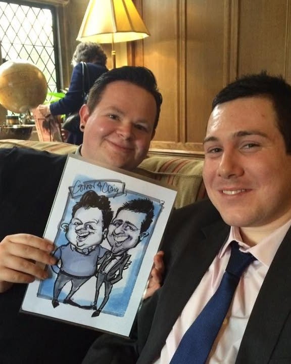 Two guests holding their shared caricature at a corporate dinner