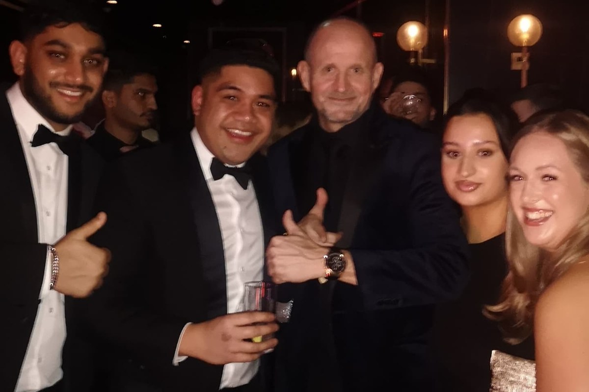 Black-tie guests laughing as the Comedy Pickpocket shows them the watch he has just taken