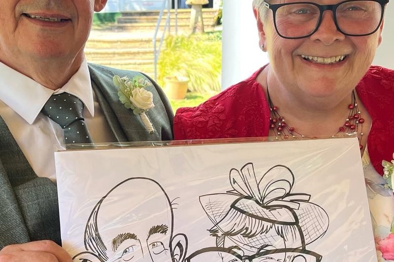 Wedding guests holding their couple caricature