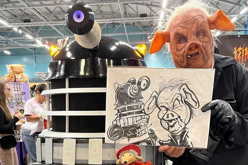 Cosplayers holding their caricature at a comic con
