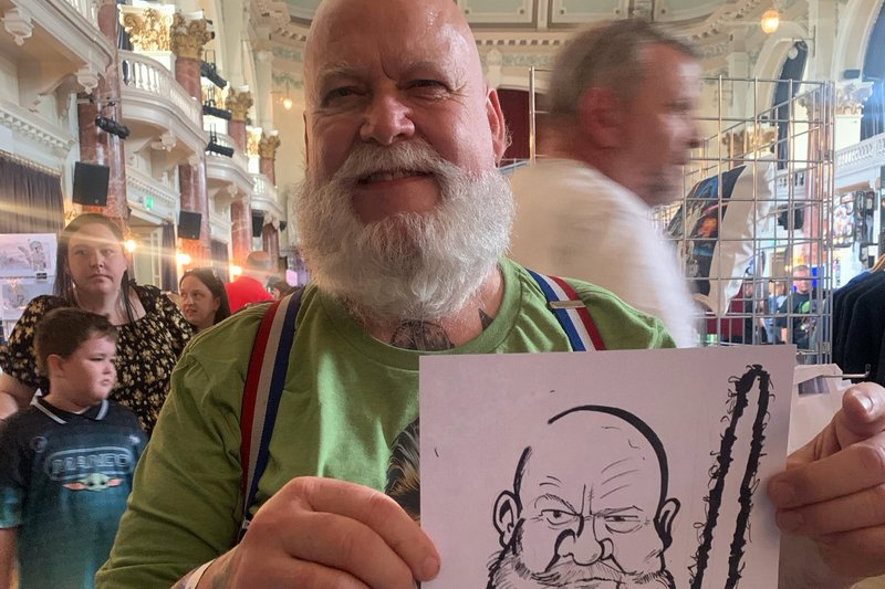 Guest holding his sci-fi themed caricature at an event