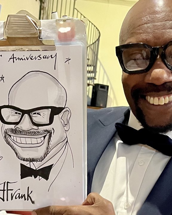 Guest in a bow tie holding his anniversary party caricature