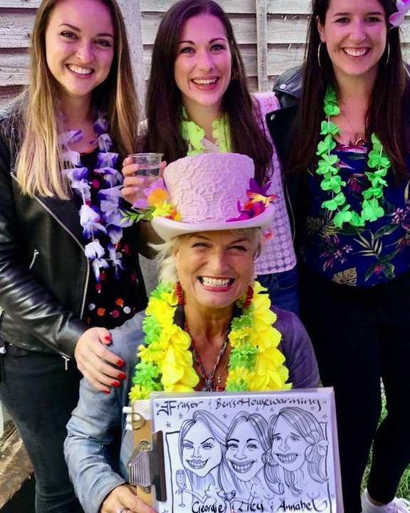 Artist in a pink top hat with three guests and their group caricature