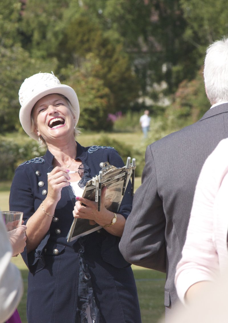 Dapper Caricatures artist laughing with a guest while drawing outdoors