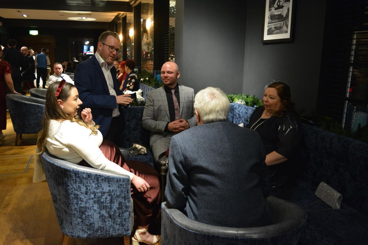 Double Take Magic performing for a group of guests seated in a hotel lounge