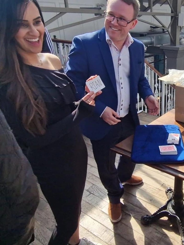 Double Take Magic, a close-up magician from Coventry, in a blue jacket, smiling as a guest laughs at a card trick