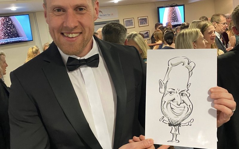 Dragon Caricatures - guest in black tie with his live caricature
